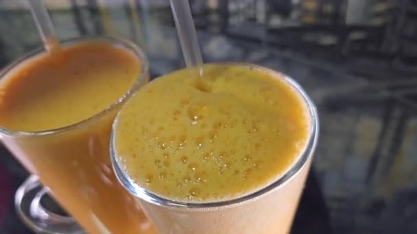パルプをオレンジジュースのグラスにストローでかき混ぜ スローモーションで飲み クローズアップします 高品質の4K映像 — ストック動画