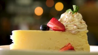 Loş ahşap masa temeli üzerinde servis edilen çilekli cheesecake. Yüksek kalite 4k görüntü