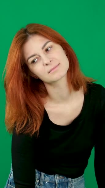 빨간머리 소녀는 바라보고 내려다보고 프레임을 바라봅니다 크로마 스튜디오 클로즈업에서 배경에 — 비디오