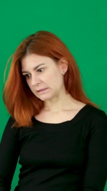 Siyah elbiseli kızıl saçlı bir kız farklı duygular ifade eder. Oh, özür dilerim, ellerimi birleştirmek istememiştim. Saçları yeşil arka planda genç bir kadın. Krom anahtar stüdyosunda. Yakın çekim kahverengi gözler. 