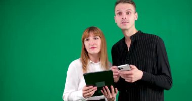 Genç çift, pembe elbiseli aile babası iki kadın el ele tutuşup cep telefonu kullanıyor ve üzerinde Pastel sade açık mavi arka planda izole edilmiş bir arama olduğunu söylüyor. stüdyo