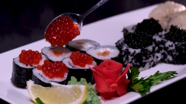 寿司与红色黑色鱼子酱放在盘子里 配上小勺特写 大量的金钱 奢侈的假日生活没有规则 富人有饭吃 有很多钱 — 图库视频影像