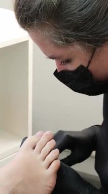 Sağlık, estetik ve ayak estetiği için pedikür ve pediatri ile estetik ve tırnakların estetik merkezinde neşter, dosya ve krem ile tam tedavisiyle. Yüksek kalite 4k görüntü