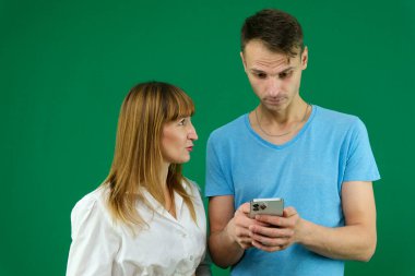 Genç bir çiftin cep telefonundan izole edilmiş arka planda poz veren komik bir video izlediği fotoğraf. Yüksek kalite fotoğraf