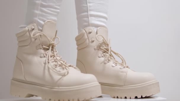 ミルキーストアで冬の秋の靴を購入するための白い背景の古典的なファッションショーに高いソールを持つ女性ベージュレースアップシューズ 高品質 — ストック動画