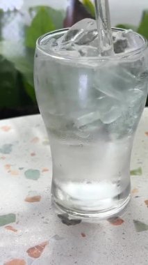 Köpüklü, ferahlatıcı soğuk bir içeceğe yaklaş. Buz küpleri köpüklü suya düşer. Yüksek kalite 4k görüntü