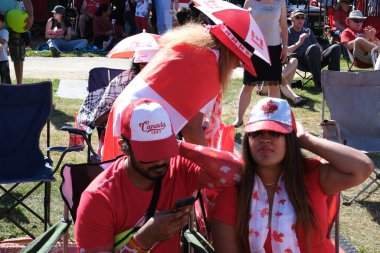 Surrey Kanada Günü. Geleneksel Kanada Günü kutlama aletleri kırmızı giysiler Kanada bayrak aileleri, kırmızı giyinmiş insanlar, Kanada Surrey 07.01.2023 bayram haftasonu meydanında yürüyorlar. 