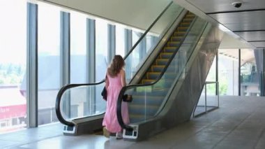 Bir dükkanda yürüyen merdivende güzel bir kadın. Yüksek kalite 4k görüntü