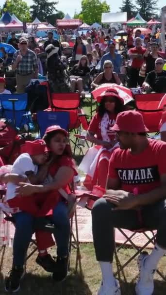 演出舞台的观众赞助观看放松 并花费时间萨里加拿大日 家家户户身着红色衣服 在加拿大萨里艺术节周末的音乐会上走在广场上 — 图库视频影像