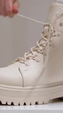 Kadınların bej rengi yüksek topuklu ayakkabıları beyaz arka plan klasik moda defilesinde kış-sonbahar sütü ayakkabısı almak için. Dikey videolar, yüksek kalite 4k görüntü