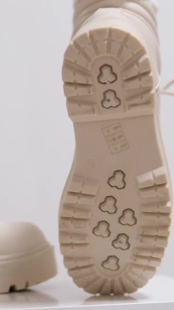 在一个白色背景的经典时装表演中 女人穿米黄色的高鞋带休闲鞋来购买冬季和秋季的乳白色鞋子 垂直视频 高质量的4K视频 — 图库视频影像