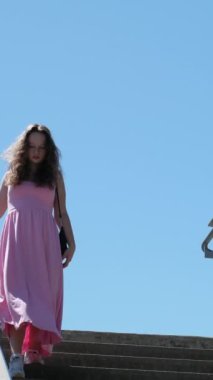 Uzun pembe elbiseli Avrupalı bir kız Kanada 'da yaya geçidinde merdivenlerden aşağı iniyor. Yüksek kalite 4k görüntü