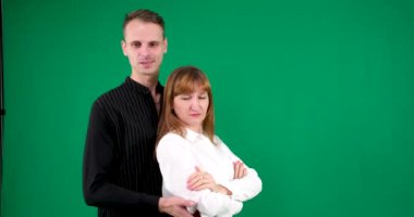 Siyah beyaz elbiseli bir adam ve bir kız, Yin-Yang, yeşil arka planda konuşuyor ve gülümsüyor. Kameraya ve birbirimize baktık. Yüksek kalite 4k görüntü