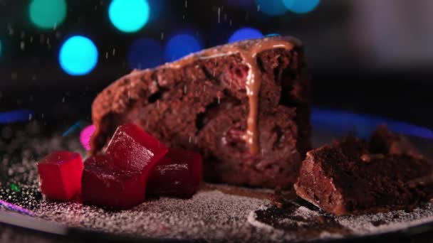 おいしいチョコレートケーキとゼリーのピース クローズアップ 粉砂糖でスプリンクル 高品質の4K映像 — ストック動画