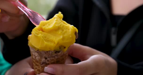 Zbliżenie Jedzenia Lodów Mango Małych Plastikowych Łyżeczek Wysokiej Jakości Materiał — Wideo stockowe