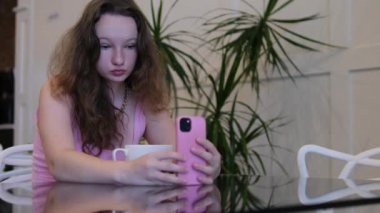 Ağır çekimde güzel bir genç kız portakalın önünde akıllı telefonuyla selfie çeker. Yüksek kalite 4k görüntü