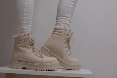 Kadınların bej rengi yüksek topuklu ayakkabıları beyaz arka plan klasik moda defilesinde kış-sonbahar sütü ayakkabısı almak için. Yüksek kalite fotoğraf