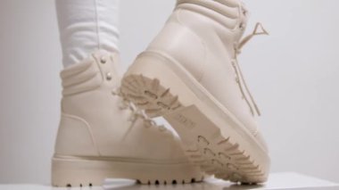 Kadınların bej rengi yüksek topuklu ayakkabıları beyaz arka plan klasik moda defilesinde kış-sonbahar sütü ayakkabısı almak için. Yüksek kalite 4k görüntü