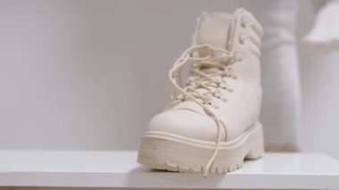 Kadınların bej rengi yüksek topuklu ayakkabıları beyaz arka plan klasik moda defilesinde kış-sonbahar sütü ayakkabısı almak için. Yüksek kalite 4k görüntü
