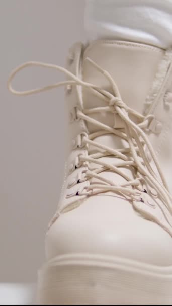 在一个白色背景的经典时装表演中 女人穿米黄色的高鞋带休闲鞋来购买冬季和秋季的乳白色鞋子 垂直视频 高质量的4K视频 — 图库视频影像