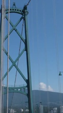 Vancouver Canada 06.07.023 Lion Gate Köprüsü Trafiği, araba trafiği Yaz günü demir yapı güneş parlıyor açık gökyüzü, dağlar. Dikey video, yüksek kalite 4k görüntü