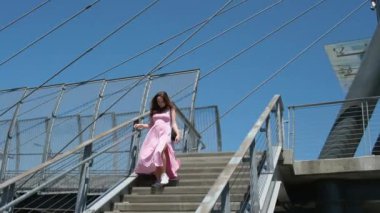 Uzun pembe elbiseli Avrupalı bir kız Kanada 'da yaya geçidinde merdivenlerden aşağı iniyor. Yüksek kalite 4k görüntü