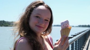 Yaz caddesinde dondurma yiyen genç, güzel esmer kadın. Ağır çekim, yüksek kalite 4K görüntü
