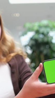 Kırmızı saçlı bir kadının cep telefonunun yeşil ekranı. Kromakey telefon reklam alanı olan kızıl saçlı kız.