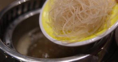 Pirinçli cam şehriye hazırlığı. Kuru Asya pirinci, vermicelli ya da erişteli sıcak su dökmek. Sağlıklı lezzetli yemekler. Yüksek kalite 