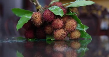 Taylandlı bir çiftçi, Chantaburi, Tayland 'da olgun rambutan meyveleriyle dolu kapları spreyliyor. Yüksek kalite 