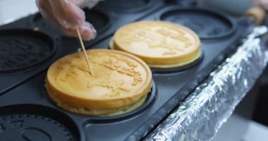 Donut, Vietnam 'da sokak yemekleri yapıyor markette desenli lezzetli taze waffle' lar hazırlıyor. Yüksek kalite 4k görüntü
