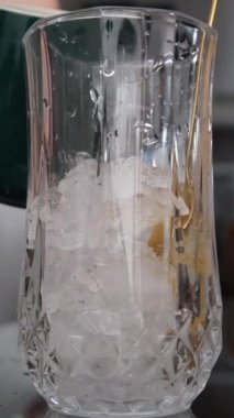 Yoğunlaştırılmış kahve karıştırılmış süt narin kadın elleri masadaki bir bardakta karamel yoğunlaştırılmış süt karıştırıyor. Yakın çekim kahve konsepti. Yüksek kalite 