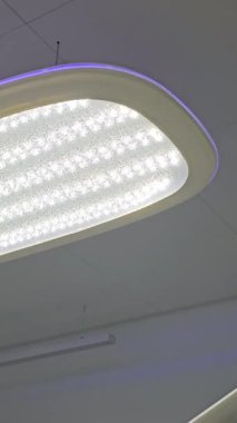 Diş kliniklerinin bürolarını aydınlatmak için aydınlatma cihazları. Diş kliniğinde lamba. Dişçi bürosunun içi. Görüş için iyi ışık, dikey video, yüksek kalite 4k görüntü