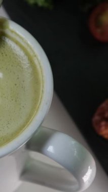 Lokantanın lezzetli içeceği sütlü sağlıklı yeşil çay. Peynirli ve salatalı kruvasan yemek, Fransız kahvaltısı, öğle yemeği, atıştırmalık, akşam yemeği, diyet, lezzetli. Dikey video, Yüksek