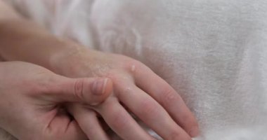 Profesyonel masajın yakın çekim videosu. Güzellik salonunda eller için masaj aromalı mum. Gençlik, cilt sağlığı, kadın güzelliği, rahatlama, dinlenme. Yüksek kalite 4k görüntü