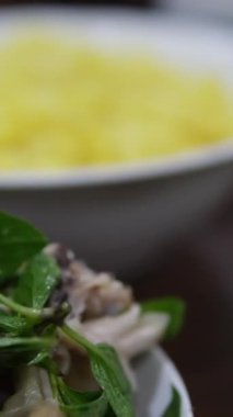 Tabaklar ve doğu yemekleri, pirinç, sebzeli et, bir sürü bitki, fesleğen, kişniş. Dikey video, yüksek kaliteli FullHD görüntüler