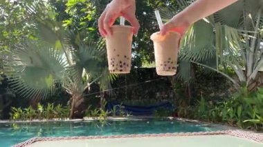 Buzlu ve Tapioca toplu iki Bubble Tea içeceği, büyük bir pipet, muhallebi incili muhallebi köpüğü çayı, gri arkaplan. Yüksek kalite 4k görüntü