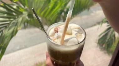 Plastik bardakta soğuk buzlu sütlü kahve ve kafede şeker kamışı pipetleri. Buzlu latte.