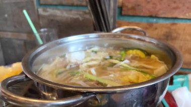 Tom Yum geleneksel Tayland yemeği yapıyor. Birisi kaynar su dolu bir tencerede mantar karıştırıyor. Kral istiridye mantarı, Anka mantarı, akciğer istiridyesi. Yan çekim. Sıcak tencere Asya