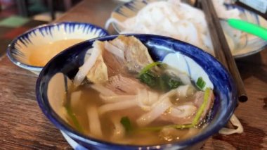 Tom Yum geleneksel Tayland yemeği yapıyor. Birisi kaynar su dolu bir tencerede mantar karıştırıyor. Kral istiridye mantarı, Anka mantarı, akciğer istiridyesi. Yan çekim. Sıcak tencere Asya