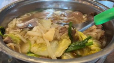 Tom Yum geleneksel Tayland yemeği yapıyor. Birisi kaynar su dolu bir tencerede mantar karıştırıyor. Kral istiridye mantarı, Anka mantarı, akciğer istiridyesi. Yan çekim. Sıcak tencere Asya