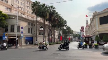 Ho Chi Minh şehrinde canlı bir akşam. Yerel halk ve canlı işaretlerle yürüyor. Asyalıların motosiklet hareketleri..