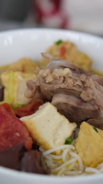 Tom Yum çorbası. Tom yum çorbasına dökülen doğranmış sebzelerin yakın plan çekimi. Yüksek kaliteli FullHD görüntüler