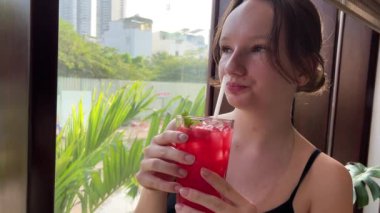 Plaj barındaki ahşap tezgahta taze ve serin karpuz suyu ve Tayland kafeteryasında bedava içki. El kamerasıyla. Güzel atletik kız karpuz suyu içiyor.