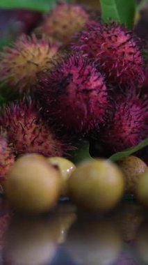 Yerel çiftçi pazarında sergilenen taze, sağlıklı, kırmızı Rambutan meyve yığınının yakın plan görüntüsü. Taze hasat edilmiş Rambutan meyvesi görüntüleri. Yüksek kalite 