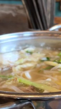 Tom Yum geleneksel Tayland yemeği yapıyor. Birisi kaynar su dolu bir tencerede mantar karıştırıyor. Kral istiridye mantarı, Anka mantarı, akciğer istiridyesi. Yan çekim. Sıcak tencere Asya