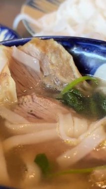 Tom Yum geleneksel Tayland yemeği yapıyor. Birisi kaynar su dolu bir tencerede mantar karıştırıyor. Kral istiridye mantarı, Anka mantarı, akciğer istiridyesi. Yan çekim. Sıcak tencere Asya