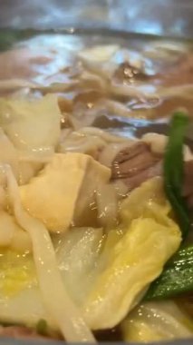 Tom Yum geleneksel Tayland yemeği yapıyor. Birisi kaynar su dolu bir tencerede mantar karıştırıyor. Kral istiridye mantarı, Anka mantarı, akciğer istiridyesi. Yan çekim. Sıcak tencere Asya