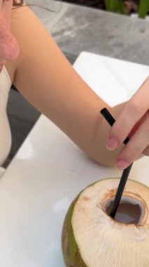 Cennet sahilinde hindistan cevizi suyu içen çekici esmer kızı yakından çek. Yüksek kalite 4k görüntü