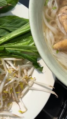 Vietnam 'da hindistan cevizi suyu kahvaltısı masasında geleneksel Vietnam pho çorbası yeşillik ve tavuk filizli fasulye filizleri kırmızı biber. Pho çorbası